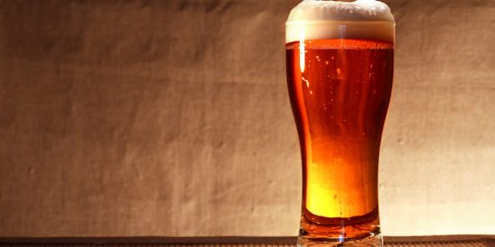 Full glass of freshness beer with foam on table against gray canvas background
** Note: Shallow depth of field