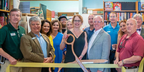 Melinda Humphreys with Mayor Woody Washam (she is holding the ceremonial scissors) and friends at a chamber ribbon-cutting