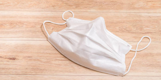 Protective medical mask on wood table background.