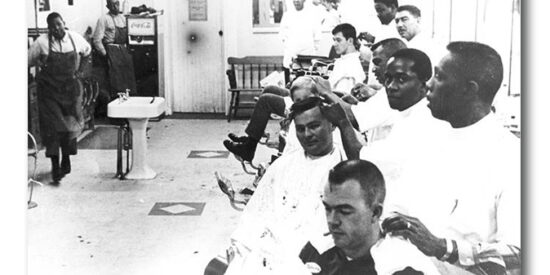 Barbers from front to back: Joe McLain, James Raeford, William Colson, unknown, Sam Reid.
Ralph Johnson is in back in front of the mirror.
