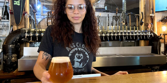 Danielle Bradley serves up an Orange Citrus IPA at Ass Clown Brewing | Photo by Jason Benavides