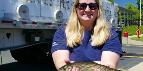 Eryn Molloy with Duke Energy holds a fish
